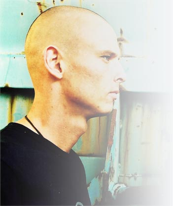 Alexander Carlborg (DjC) Portrait of Alexander Carlborg (DjC), shaved head, looking to the side, in pale blue light.